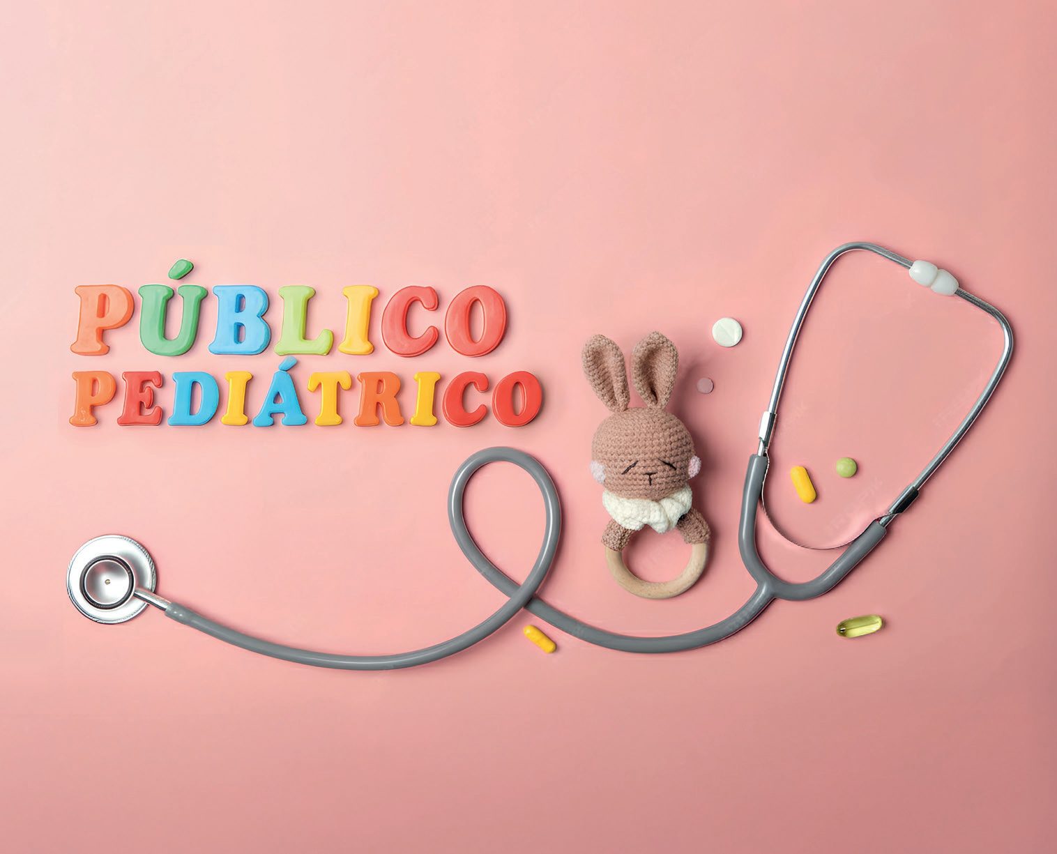 Estetoscópio, chocalho de crochê em forma de coelho e cápsulas sobre fundo rosa, com as palavras Público pediátrico em letras coloridas