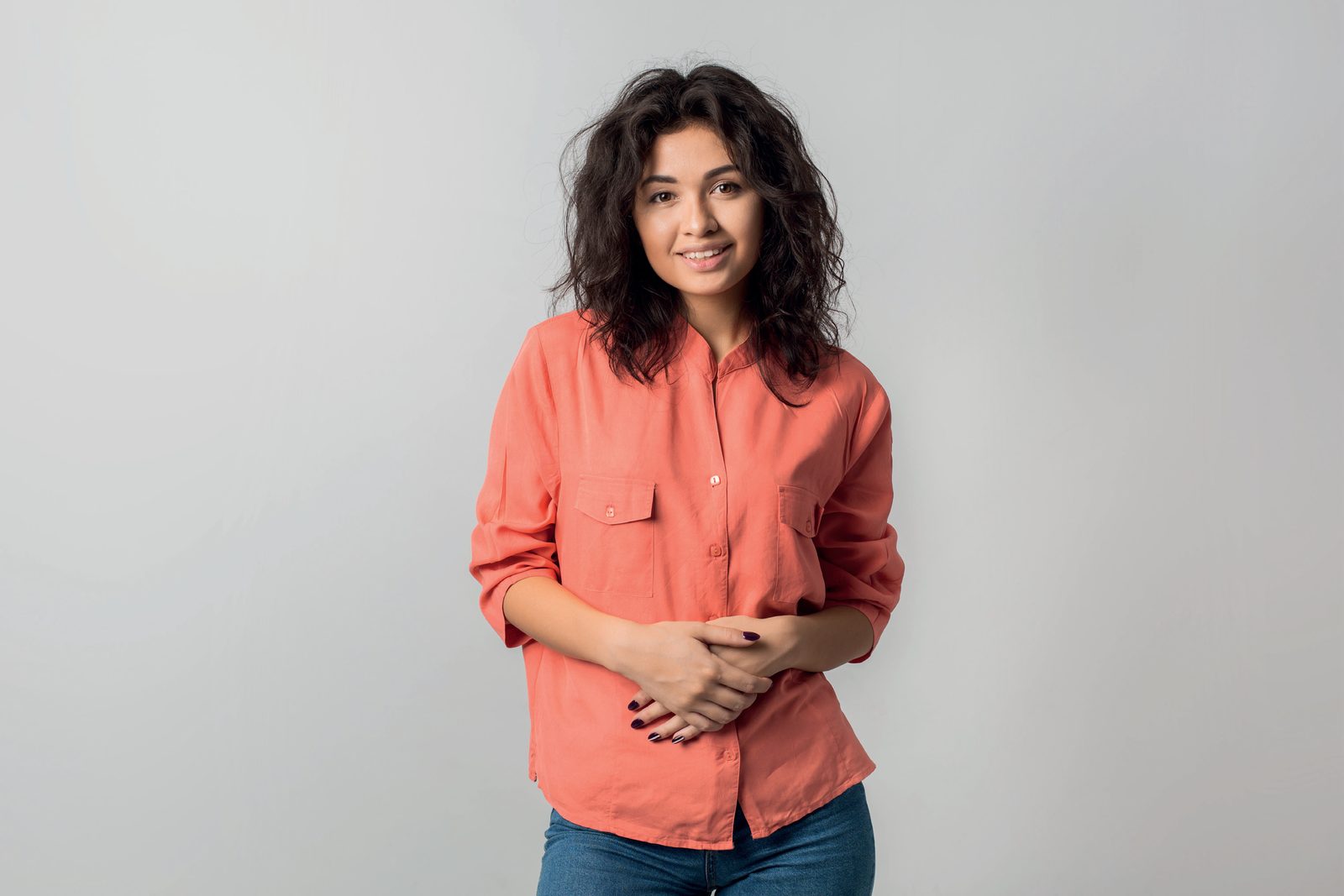 Mulher jovem sorrindo, de camisa coral