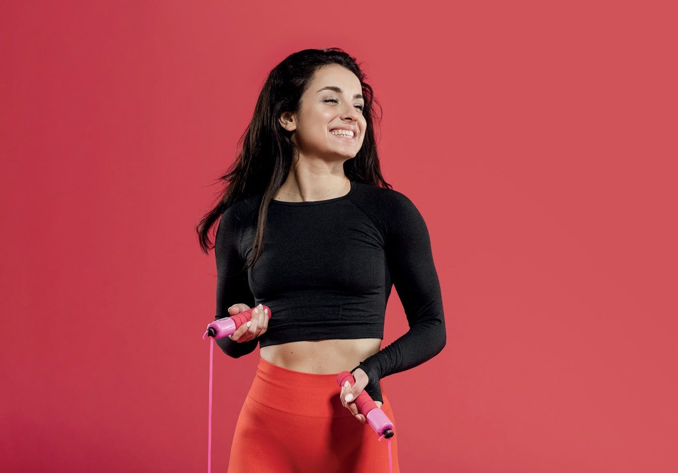 Mulher sorrindo pulando corda
